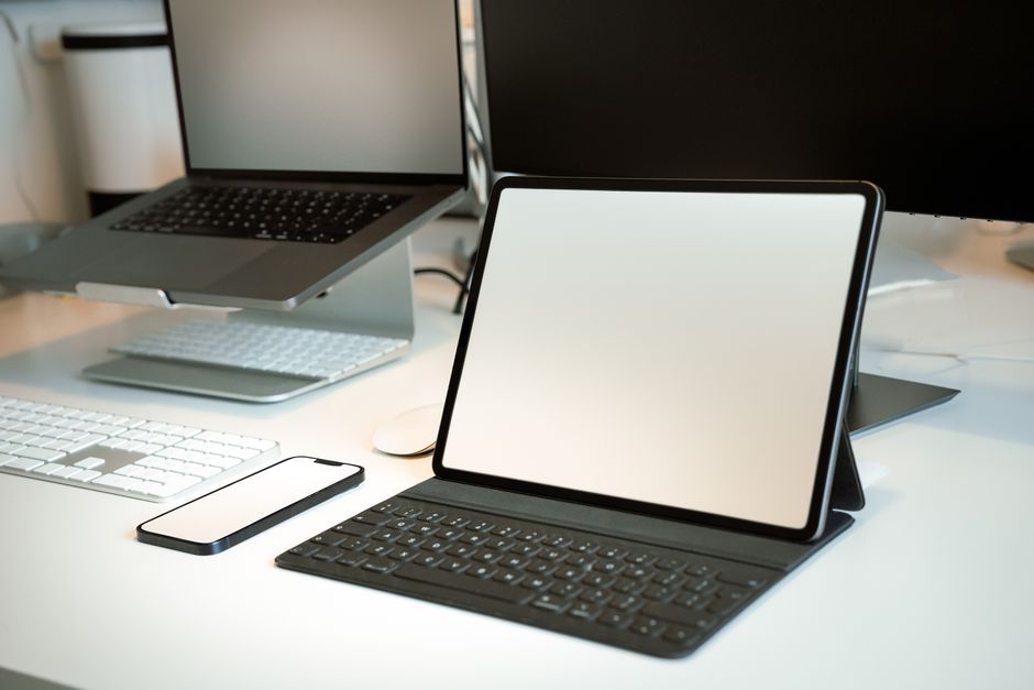 A clean, minimalist office desk with a tablet, strategically placed before a large window with a beautiful and expansive river view, symbolizing modern real estate strategy.